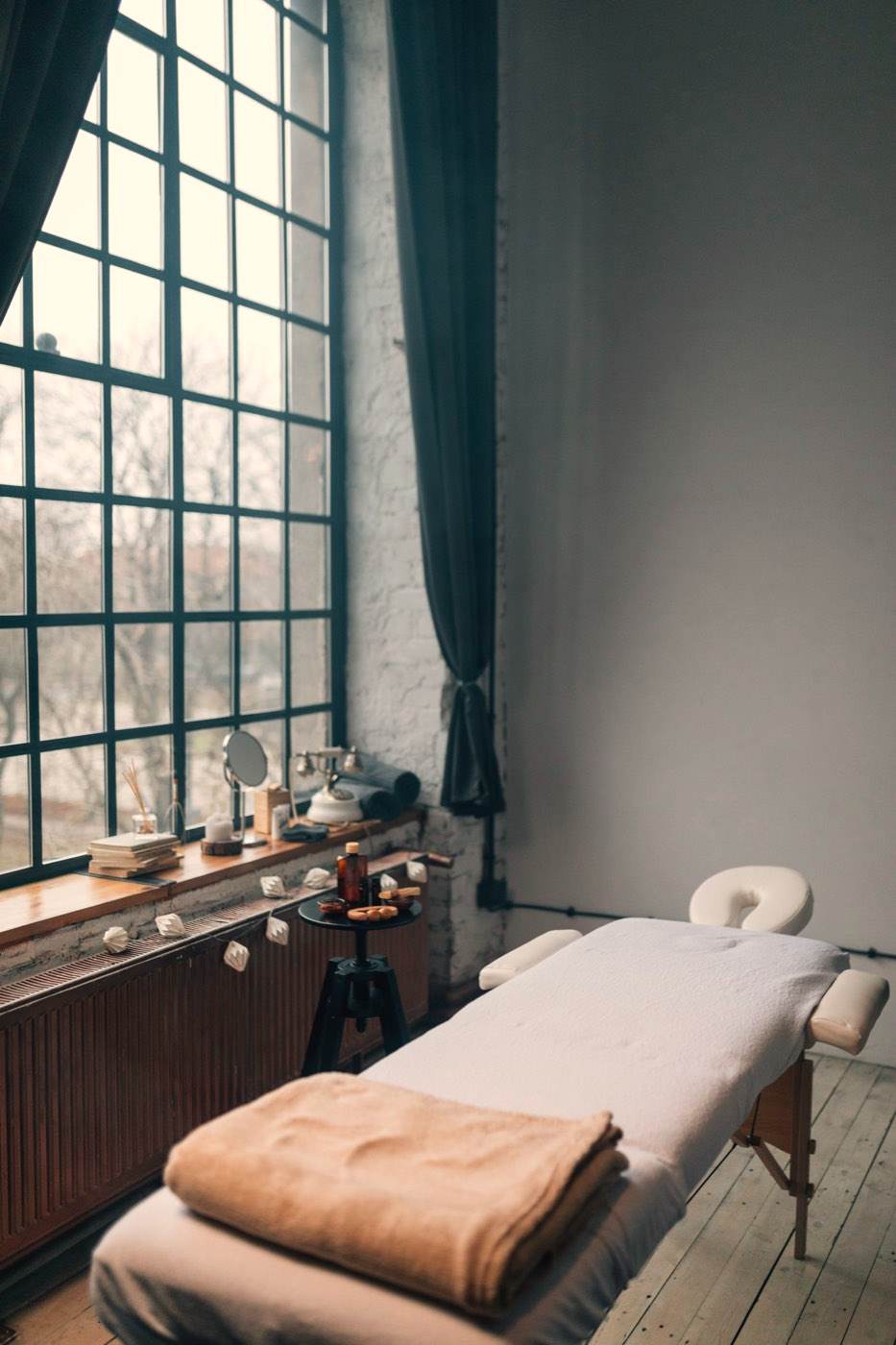 Cabine de soin calme, table de massage près d'une grande verrière
